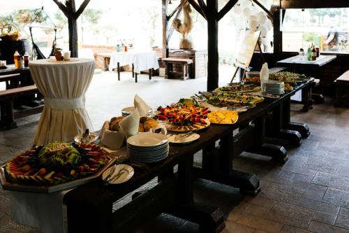 a long table with many plates of food on it at Hotel Picok in Ðurđevac
