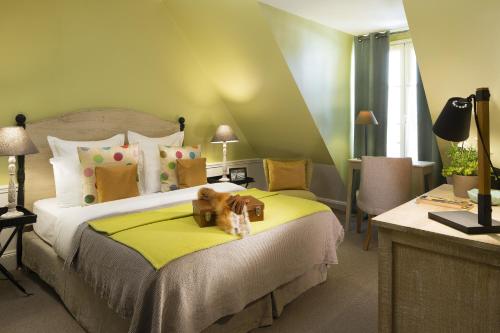 a bedroom with a bed with two teddy bears on a yellow blanket at Hotel Le Petit Chomel in Paris