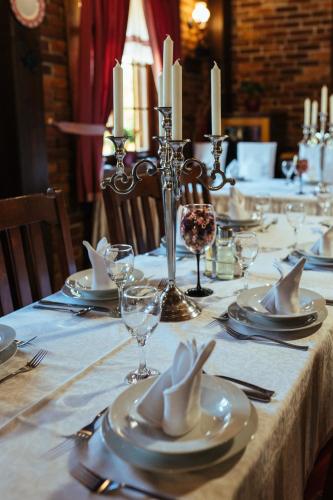 a table with plates and napkins on a table with candles at Hotel Picok in Ðurđevac