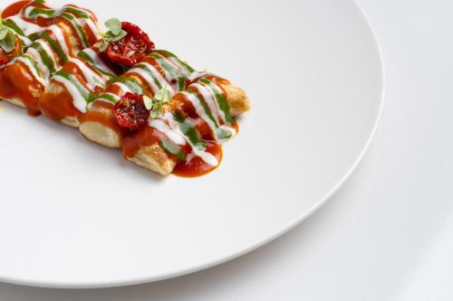 a piece of pizza on a white plate at Relais Bellaria Hotel & Congressi in Bologna