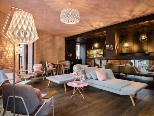 a lobby with couches and tables and a bar at Libertine Lindenberg in Frankfurt/Main