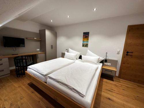 a bedroom with a large white bed and a desk at Gasthof Goldene Krone in Pottenstein