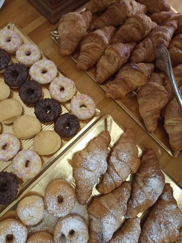 een vitrine met verschillende soorten gebak en croissants bij HOTEL LA PLAYA in Cervia