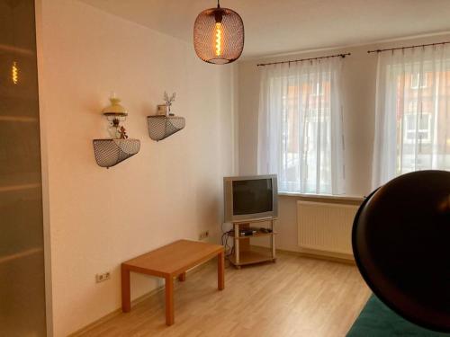 un salon avec une télévision et une table dans l'établissement Altes Uhrwerk, à Hasselfelde