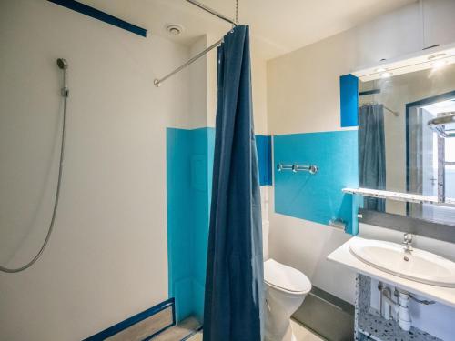 La salle de bains bleue est pourvue de toilettes et d'un lavabo. dans l'établissement Vacancéole - les villas du lac, à Soustons