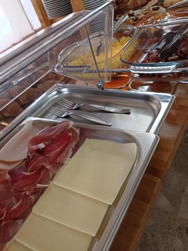 een toonbank met kaas en vleeswaren in een buffet bij HOTEL LA PLAYA in Cervia