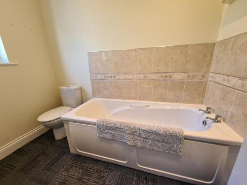 a bathroom with a white tub and a toilet at Upper Tresulian in Saint Mawes