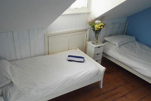 a bedroom with two beds and a vase of flowers at Seaside, Exmouth Centre - sleeps 6+ in Exmouth