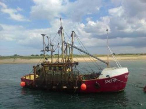 a shrimp boat sitting in the water at Seaside, Exmouth Centre - sleeps 6+ in Exmouth