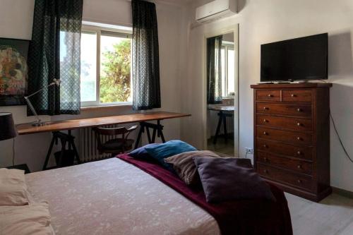 Schlafzimmer mit einem Bett, einem Schreibtisch und einem TV in der Unterkunft RQ Apartments in Bari