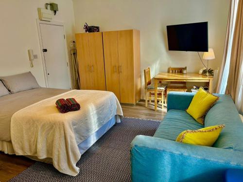 uma sala de estar com uma cama e um sofá em Studio 5 mins walk from Seven Sisters Station em Londres