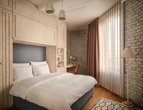 Un dormitorio con una gran cama blanca y una ventana en Libertine Lindenberg, en Frankfurt