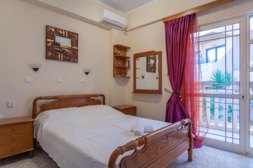 1 dormitorio con cama y ventana en CHRISTINE SEASIDE APARTMENTS IN CHANIA en Stalós