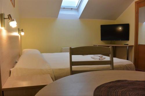 a hotel room with two beds and a flat screen tv at Alba Hotel in Jūrmala