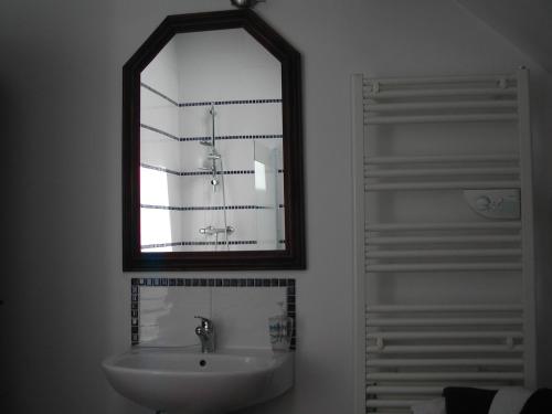 bagno con specchio e lavandino di L'Auvraire B&B a Coulouvray-Boisbenâtre