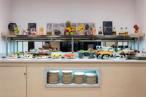 um buffet com muita comida em exposição em Petit Palace Arturo Soria Alcalá em Madrid