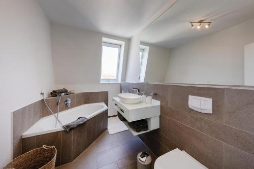 ein Badezimmer mit einem Waschbecken und einer Badewanne in der Unterkunft Zelle 43 in Münster