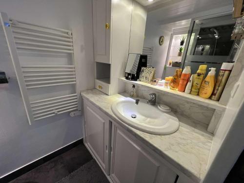 une salle de bain blanche avec un lavabo et un miroir dans l'établissement Studio mezzanine avec clim, piscine, proche plage, ascenseur, lave-linge - FR-1-702-27, au Cap d'Agde
