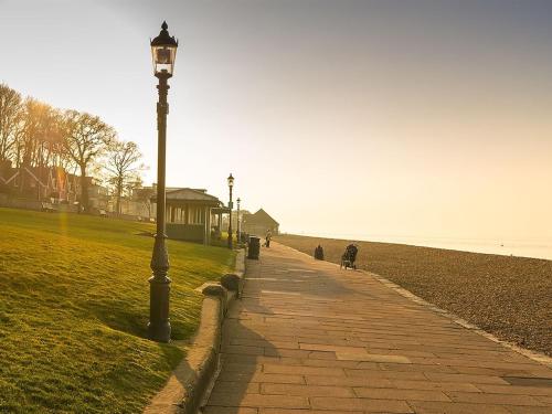 a street light on a sidewalk next to a beach at Endeavour House in Cowes