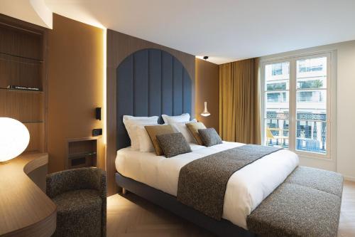 Habitación de hotel con cama y silla en La Source Exclusive Apartment, en París