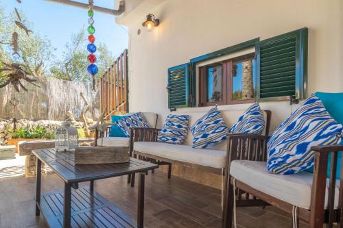 a patio with blue and white pillows and a table at Cas Pati (Son Moja) in Santanyi