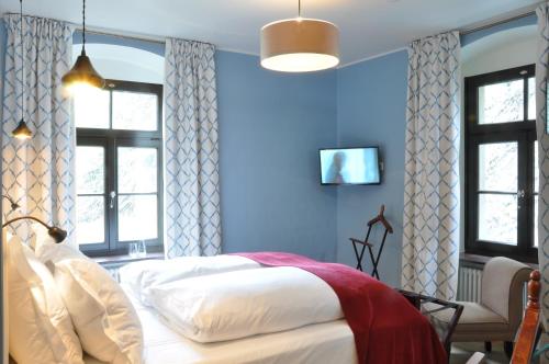 a bedroom with blue walls and a bed and windows at Burg Reichenstein in Trechtingshausen