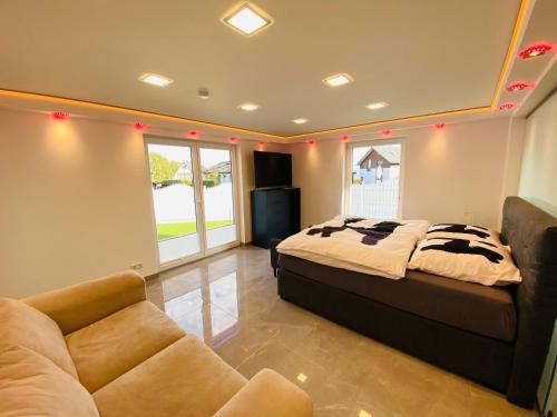 Un dormitorio con una cama y un sofá en una habitación. en Luxus Apartment Pasha & Nero, en Geisenheim