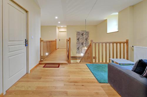 een woonkamer met een bank en een trap bij Petit Marigny - Belle maison pour 10 voyageurs in Alexain
