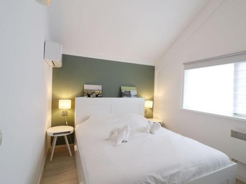 a white bed in a room with a window at Welcoming holiday home in Grou with bubble bath in Grou