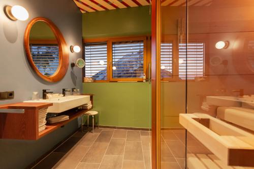 a bathroom with a sink and a mirror at Wohlfühlhotel Hubertushof in Stuben am Arlberg