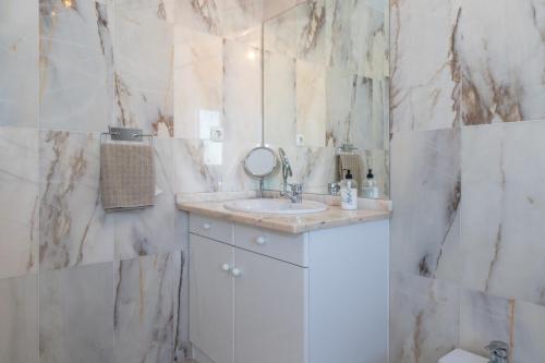 a white bathroom with a sink and a mirror at Penthouse with a fantastic view in La Cala de Mijas