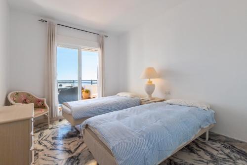 卡拉德米哈斯的住宿－Penthouse with a fantastic view，带窗户的客房内的两张床
