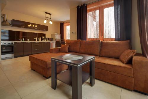 salon z kanapą i stołem w obiekcie Przytulny i Gustowny Apartament Sun Seasons 24 w Karpaczu by Noclegi Renters w mieście Karpacz