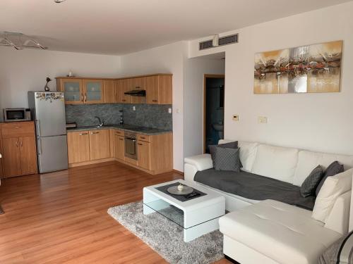 a living room with a white couch and a kitchen at Vienna Gate apartment in Bratislava