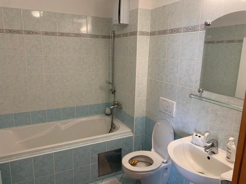 a bathroom with a toilet and a sink and a tub at Vienna Gate apartment in Bratislava