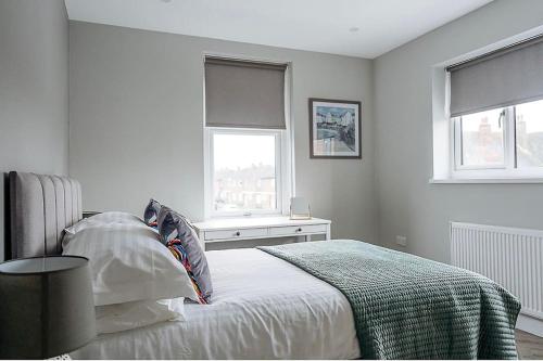 - une chambre blanche avec un lit et 2 fenêtres dans l'établissement Beach Seaside Apartment sleeps 4 Lytham St Annes, à Lytham St Annes