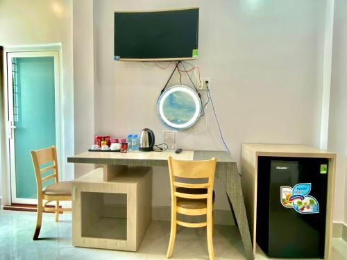 a room with a table and chairs and a tv at Hotel Phước Thịnh in Vĩnh Long