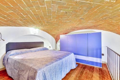 ein Schlafzimmer mit einem Bett und einer Ziegelwand in der Unterkunft Carpe Diem in Lerici