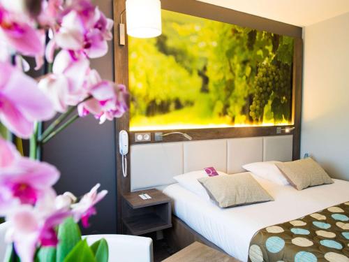 a hotel room with two beds and a fish tank on the wall at Mercure Beaune Centre in Beaune