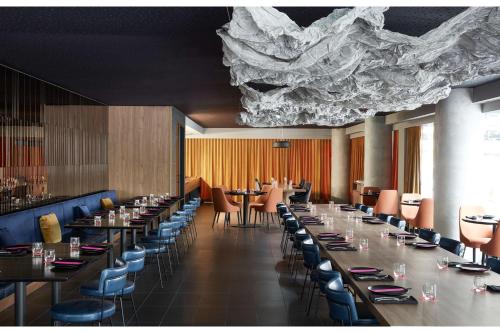 uma sala de jantar com mesas longas e cadeiras em Quincy Hotel Melbourne em Melbourne