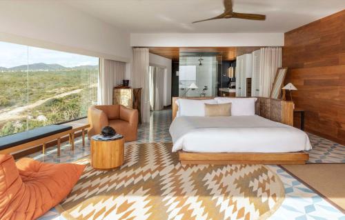 a bedroom with a bed and a living room at The Cape, a Thompson Hotel, part of Hyatt in Cabo San Lucas