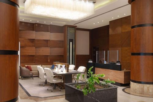 a conference room with a table and chairs and a chandelier at Ramada by Wyndham Erbil Gulan Street in Erbil