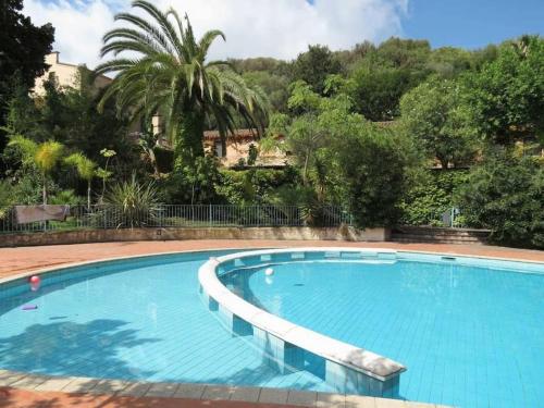 een groot blauw zwembad met een palmboom op de achtergrond bij Residence Blue living in Tortolì
