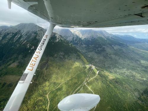 a view of the wing of an airplane flying over a mountain at Mlyn Tatry in Veľký Slavkov