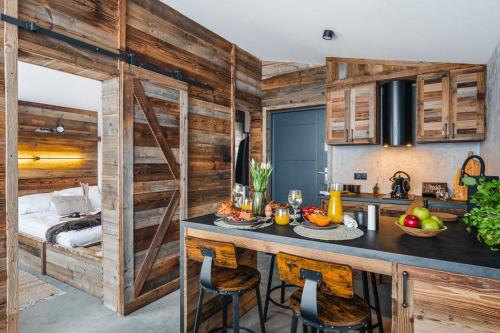 a kitchen with wooden walls and a table with food on it at Stare Szałasy in Klikuszowa