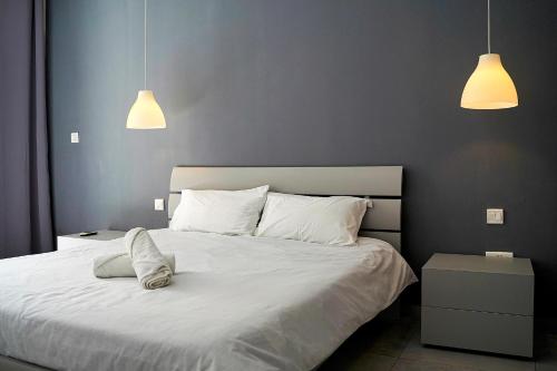 - une chambre avec un lit blanc et deux lampes suspendues dans l'établissement Modern Apartments Close to the Sea, à Il-Gżira