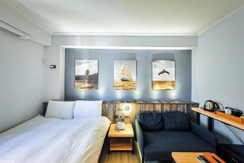 a small room with a bed and a couch at 亞馨文旅 近東大門夜市 有免費停車場 可自助入住 in Hualien City