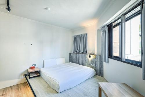 a bedroom with a white bed and a window at 亞馨文旅 近東大門夜市 有免費停車場 可自助入住 in Hualien City