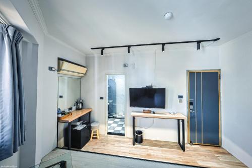 a room with a desk and a television in a room at 亞馨文旅 近東大門夜市 有免費停車場 可自助入住 in Hualien City