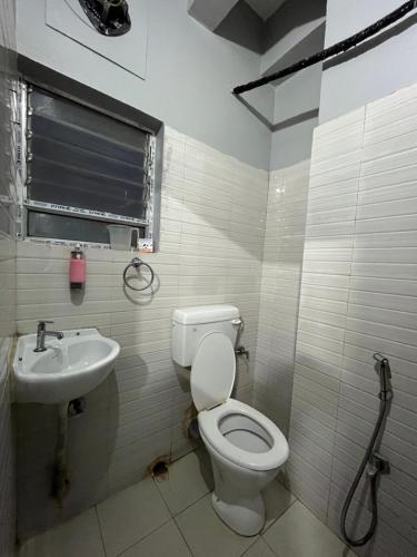a bathroom with a toilet and a sink at Urban Inn Rukminigaon in Guwahati